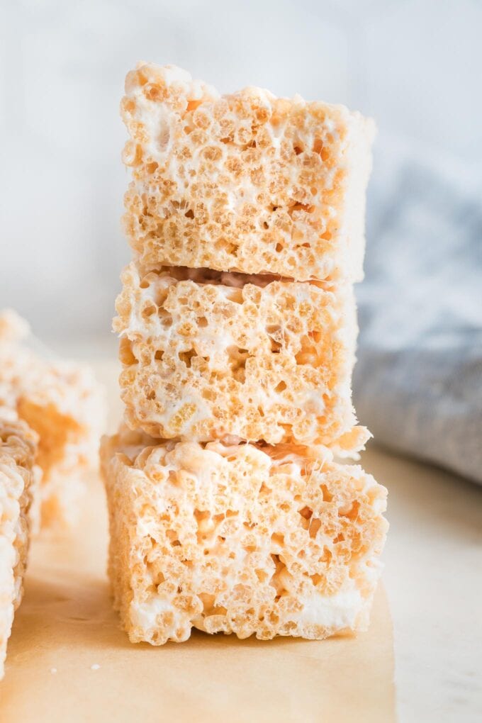 Stack of three extra-thick rice Krispie treats with visible pockets of marshmallows mixed in.