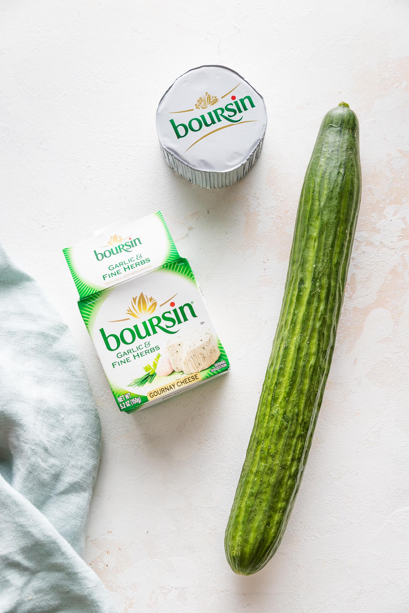 An English cucumber and a package of garlic herb Boursin cheese.