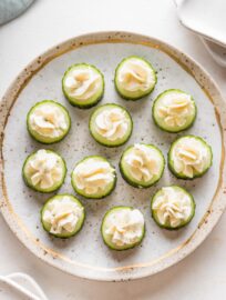 Pretty gold rimmed plate with Boursin cucumber bite appetizers.