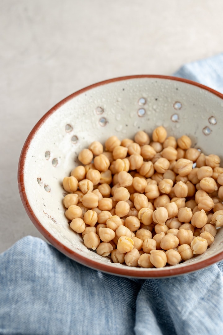 Close-up of chickpeas drained and rinsed in a stoneware colander.