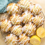 Glazed lemon poppy seed muffins on a cooling rack.