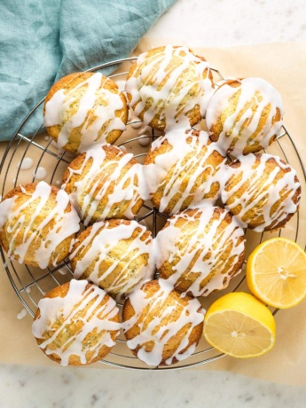 Glazed lemon poppy seed muffins on a cooling rack.