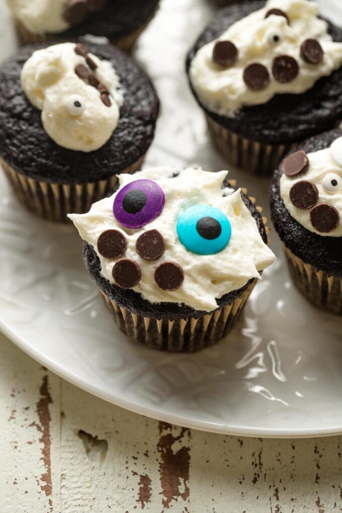 Chocolate cupcake with messy white frosting and colorful decorations.