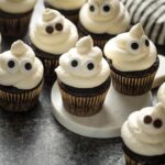 Ghost cupcakes arranged on a black background.