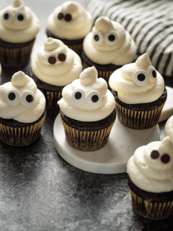 Ghost cupcakes arranged on a black background.