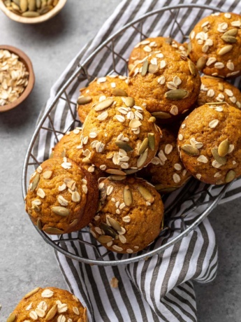 Pumpkin muffins stacked in a basket, ready to share.