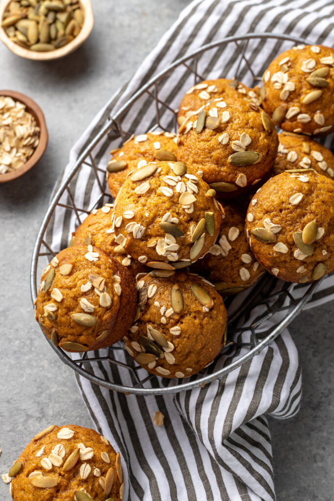 Pumpkin muffins stacked in a basket, ready to share.