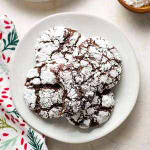 Small white plate filled with chocolate crinkle cookies.