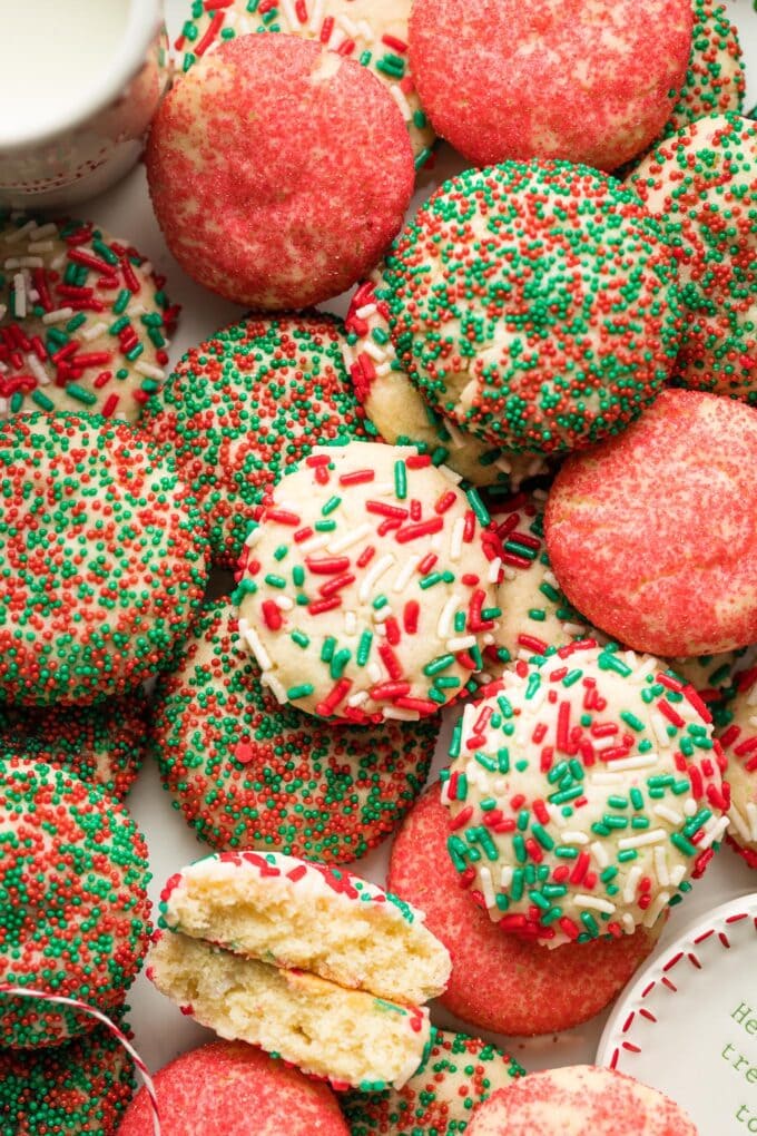 Close up of sugar cookies rolled in a variety of red and green sprinkles.