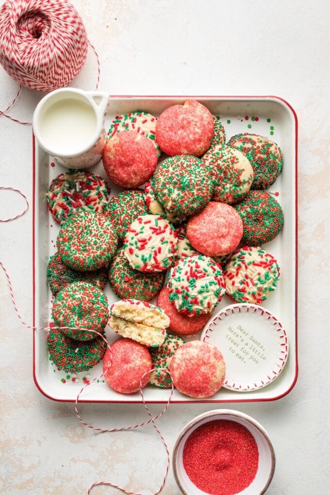 Tray holding sprinkle sugar cookies set out with milk for Santa.