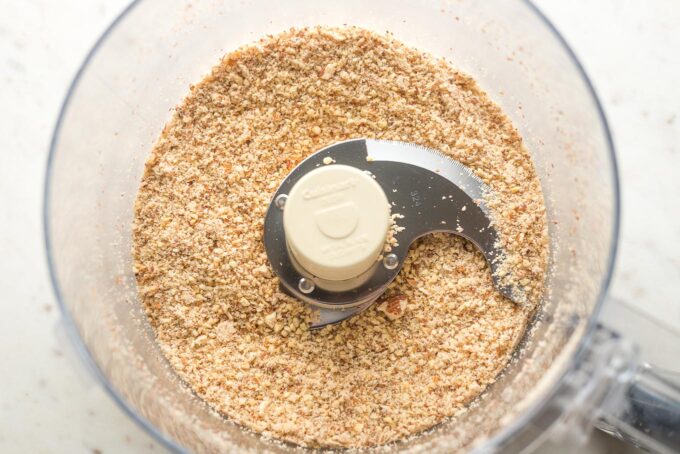 Fine-ground almonds in the bowl of a food processor.