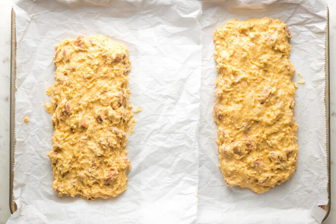 Two logs of cookie dough shaped into mounds for baking biscotti.