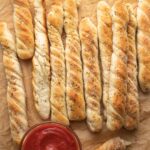 Homemade breadsticks with marinara sauce for dipping.