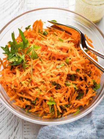 Clear glass bowl holding a French carrot salad.