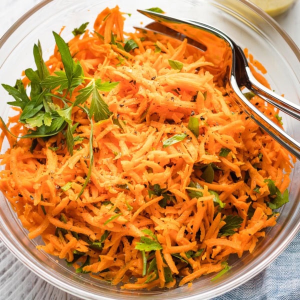 Clear glass bowl holding a French carrot salad.