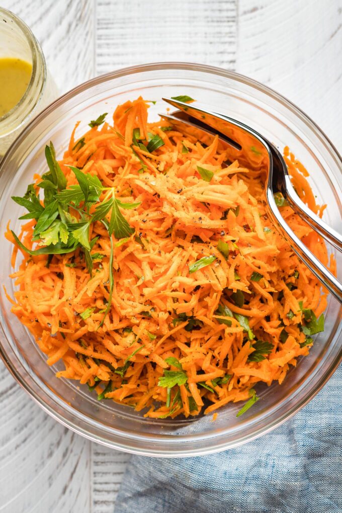 Clear glass bowl holding a French carrot salad.