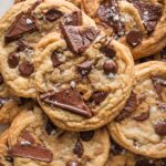 Close up overhead view of a salted caramel chocolate chip cookie with sea salt flaked on top.
