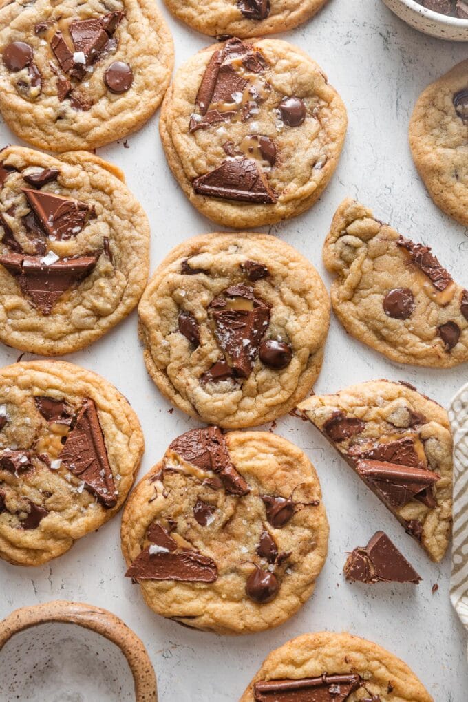 Rows of salted caramel chocolate chip cookies arranged on a countertop to cool and set.