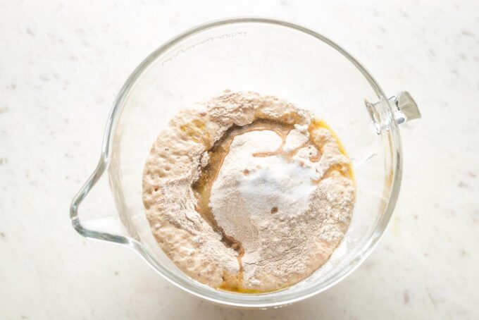 More flour and other ingredients added to the clear mixing bowl.