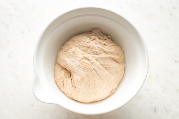 Dough transferred to a greased mixing bowl to rise - dough is about halfway filling the bowl.