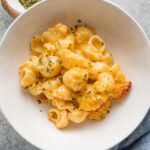 Bowl of creamy baked mac and cheese with breadcrumb topping.