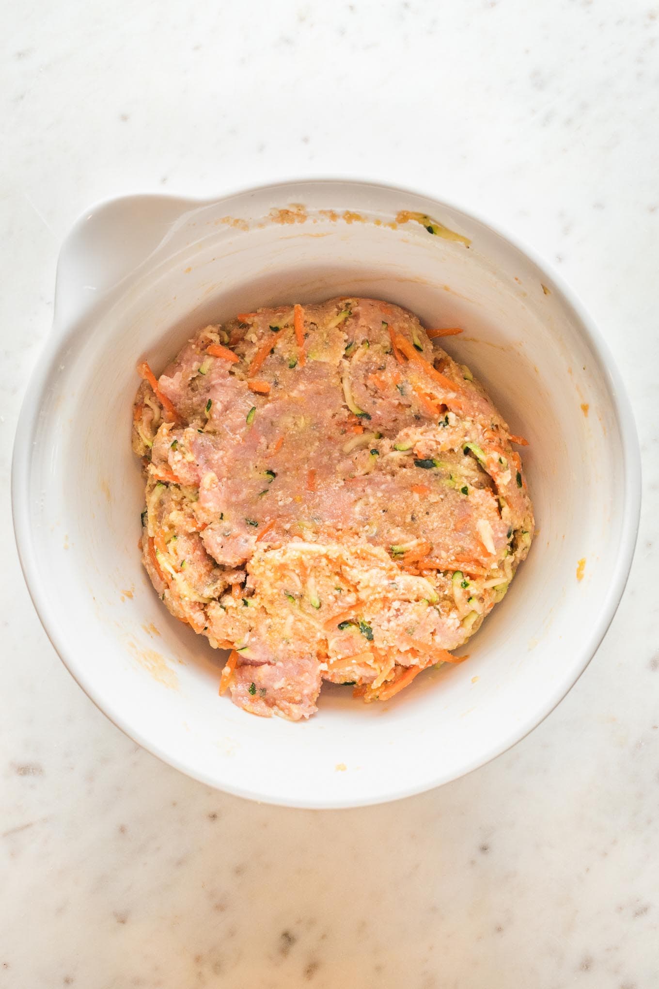 Mixture for baked turkey meatballs combined in a prep bowl.