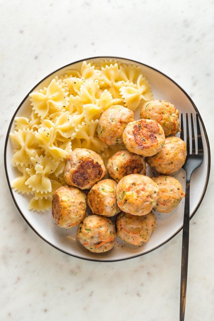 Plate of baked turkey meatballs served with farfalle.