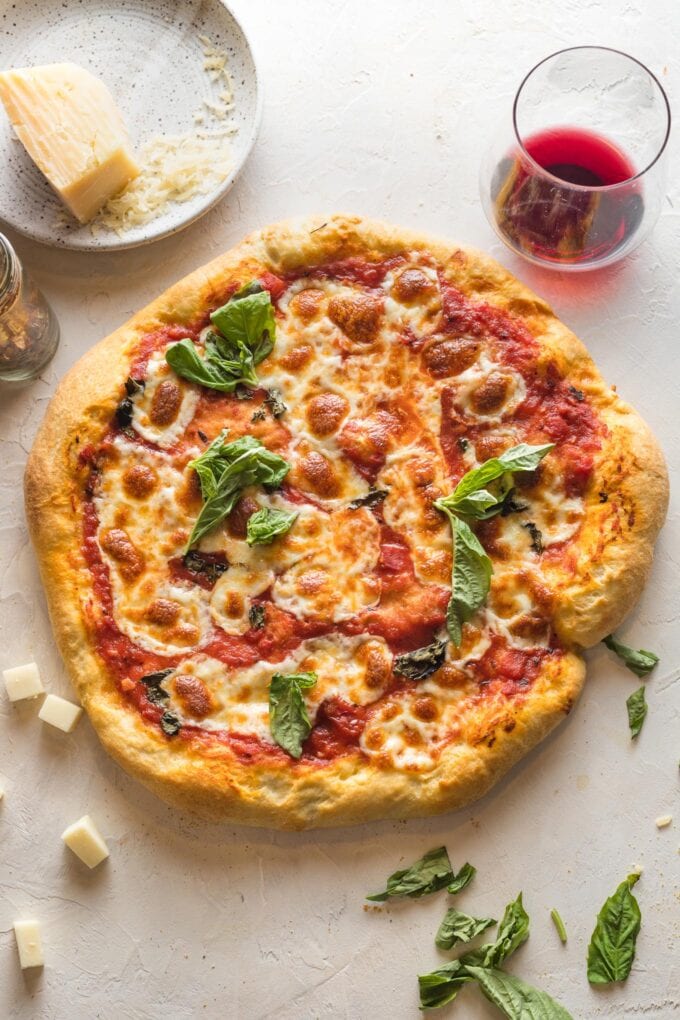 A homemade margherita pizza fresh out of the oven and ready to slice.