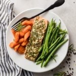 A plate of rosemary garlic salon with carrots and green beans.