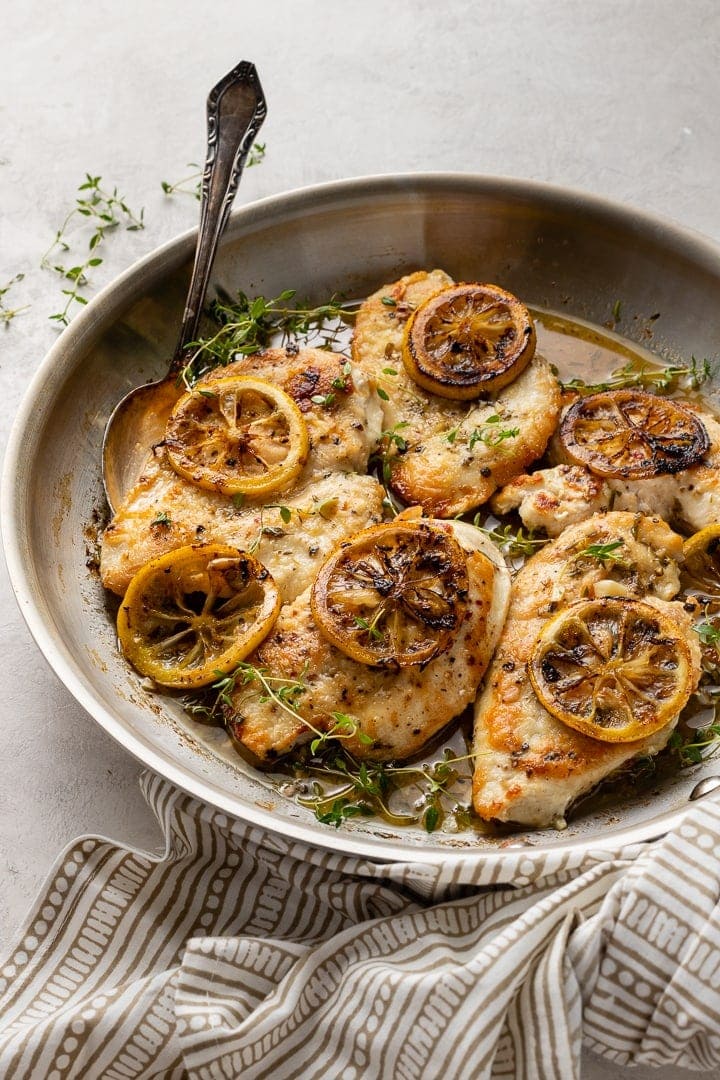 A skillet filled with lemon thyme chicken breasts, a quick and easy weeknight dinner.