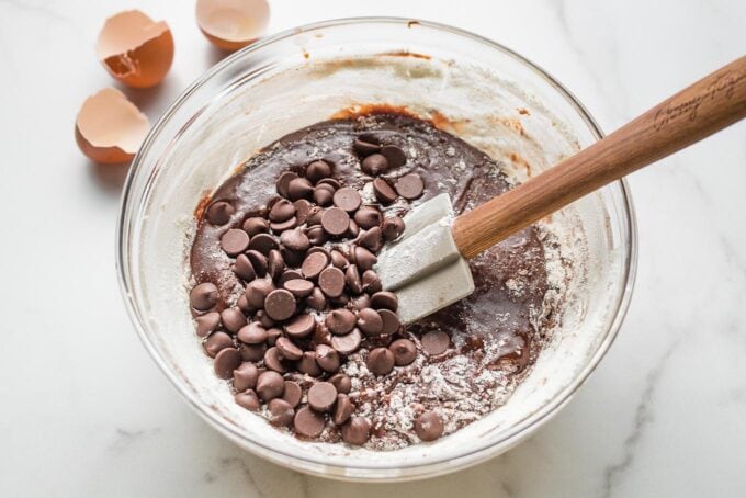Prep bowl holding brownie batter with chocolate chips sprinkled on top.