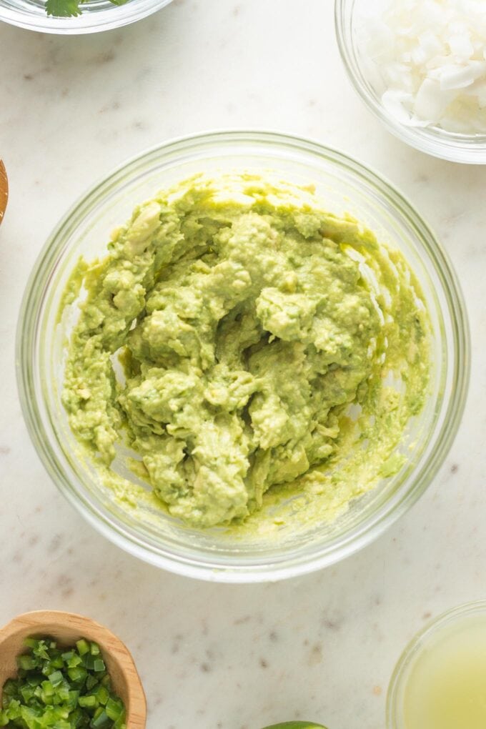 Mashed avocado in a mixing bowl.