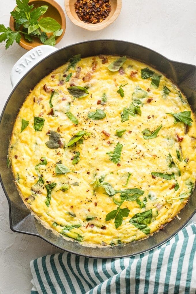 Baked frittata in a white cast-iron pan.