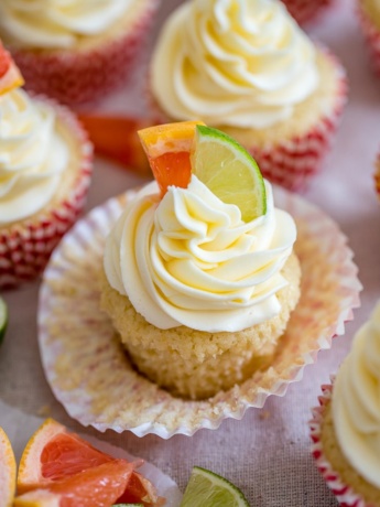 Close-up of a Paloma cupcake with grapefruit and lime slices for garnish.