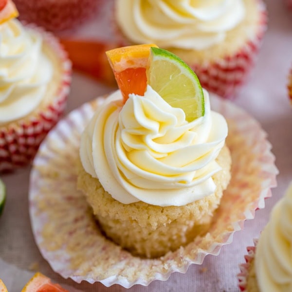 Close-up of a Paloma cupcake with grapefruit and lime slices for garnish.