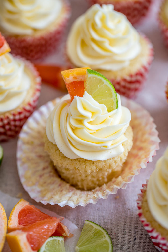 Close-up of a Paloma cupcake with grapefruit and lime slices for garnish.