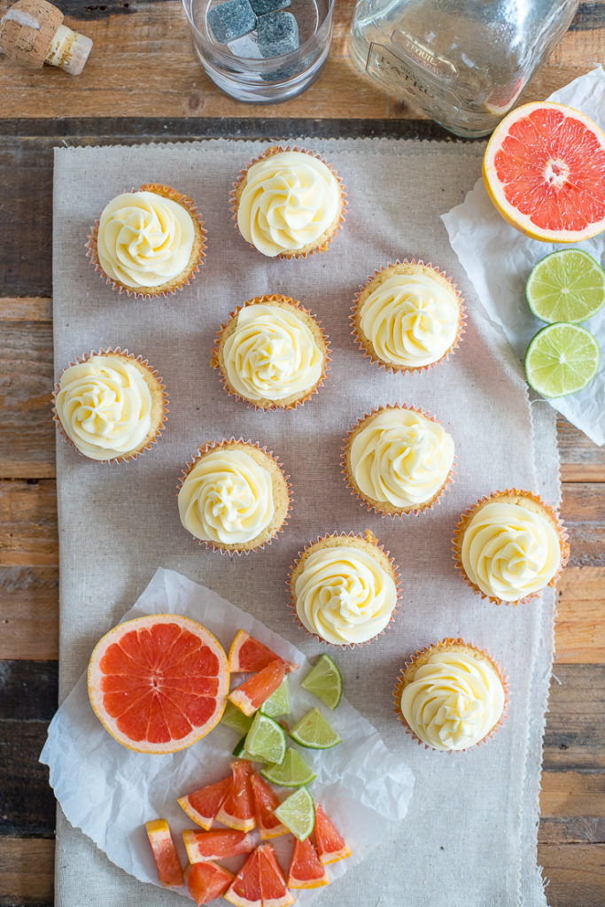 Flat-lay of Paloma cupcakes with grapefruit and lime wedges scattered around.