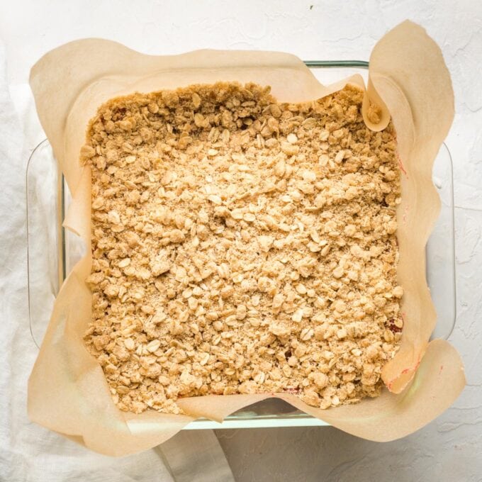 Bars fully covered with topping in a square glass baking pan.