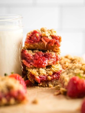 Close-up of three stacked strawberry rhubarb crumble bars.