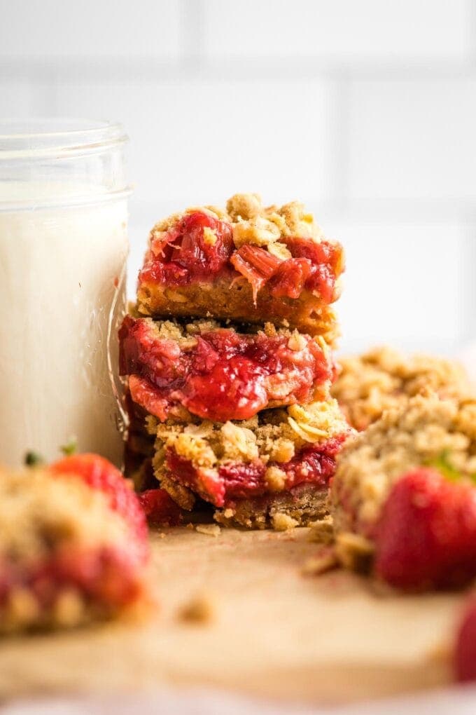 Close-up of three stacked strawberry rhubarb crumble bars.