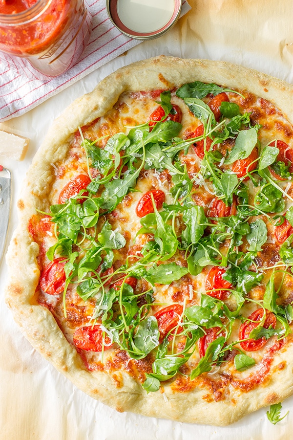 Pizza with marinara sauce, bacon, pan-roasted tomatoes, and fresh arugula. Fresh and delicious!