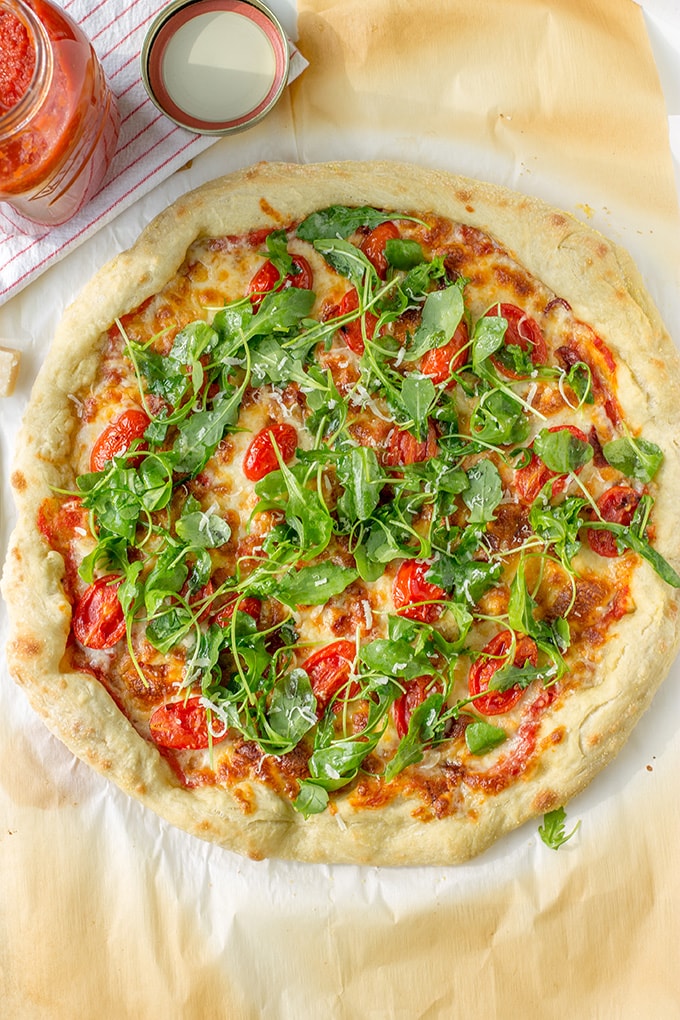 Pizza with marinara sauce, bacon, pan-roasted tomatoes, and fresh arugula. Fresh and delicious!