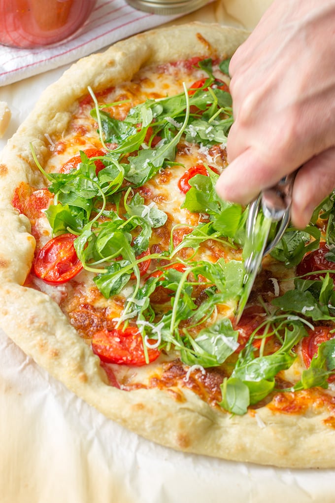 Pizza with marinara sauce, bacon, pan-roasted tomatoes, and fresh arugula. Fresh and delicious!