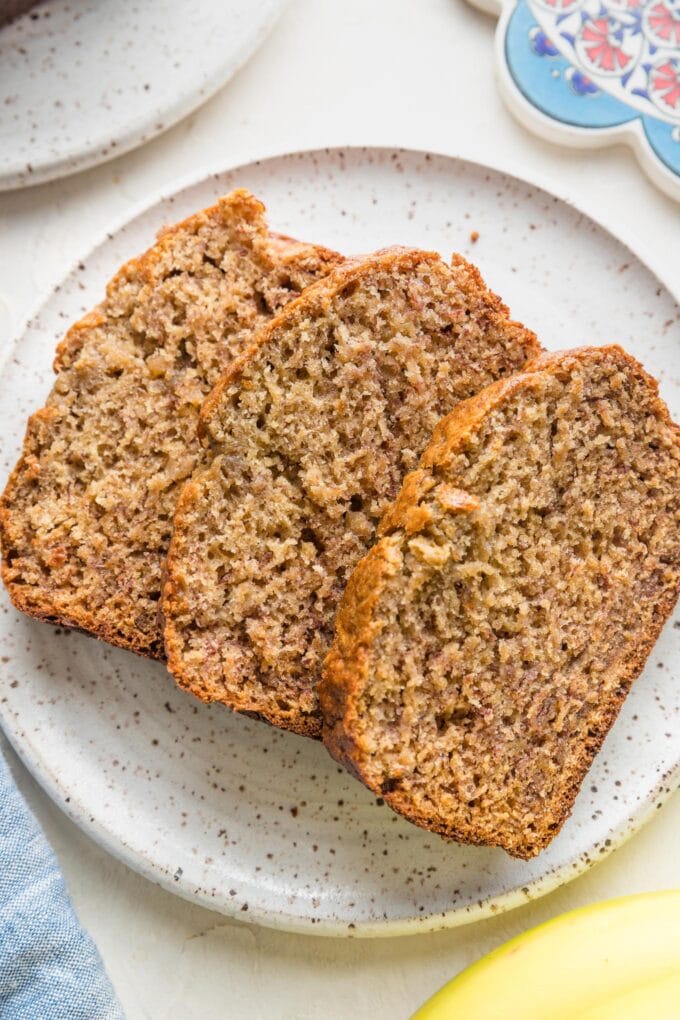 Slices of banana bread laid out on a white plate.