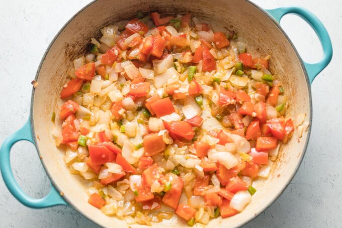 Cooked onion and tomato mixture in skillet.