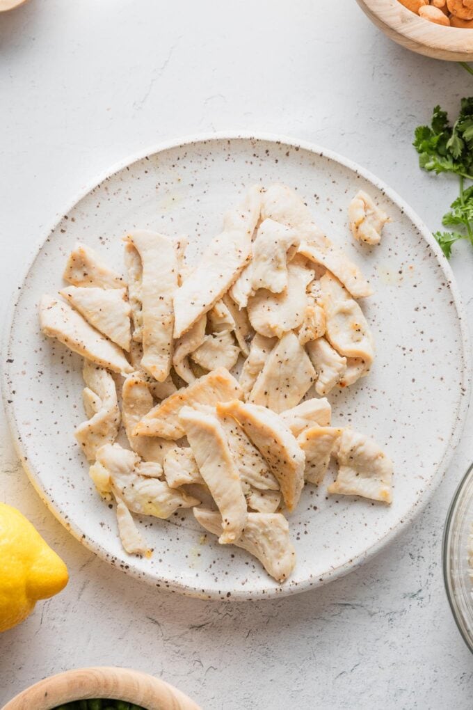 Browned bite-sized pieces of chicken on a ceramic plate.