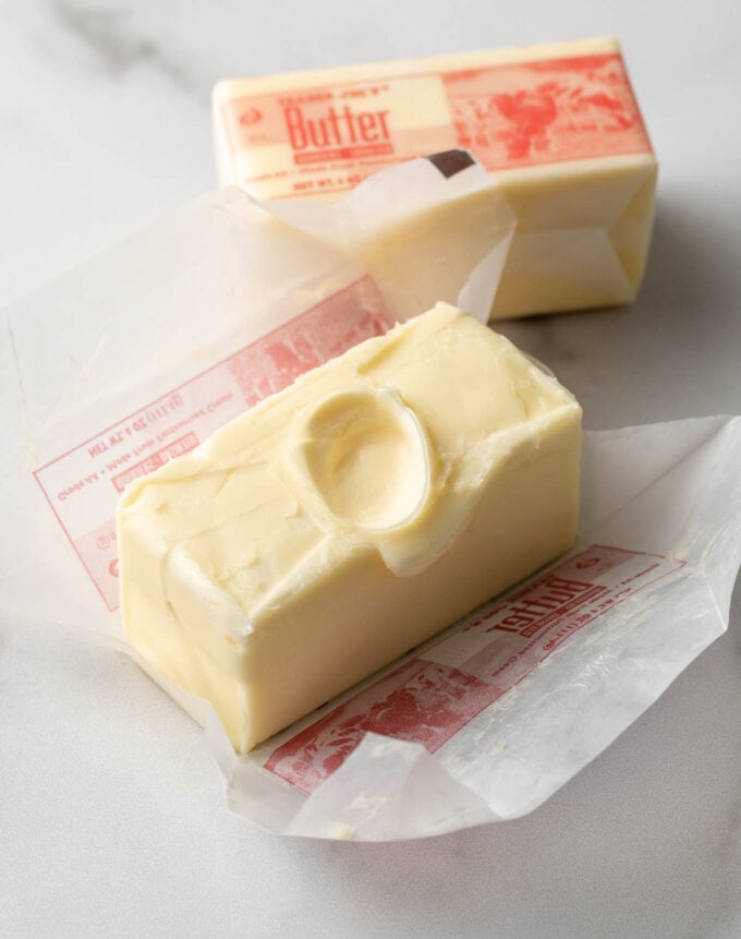 Close-up of perfectly room temperature butter, with a fingerprint shown in the middle to demonstrate that the butter conforms to the touch but doesn't melt.