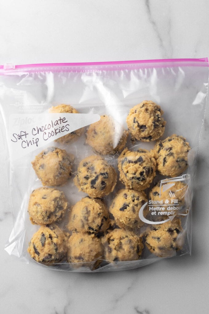Chocolate chip cookie dough balls in a freezer-safe bag, ready to store.