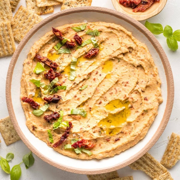 Bowl of sun-dried tomato dip, served with crackers.