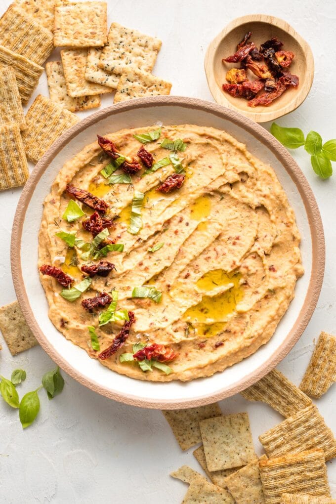 Bowl of sun-dried tomato dip, served with crackers.